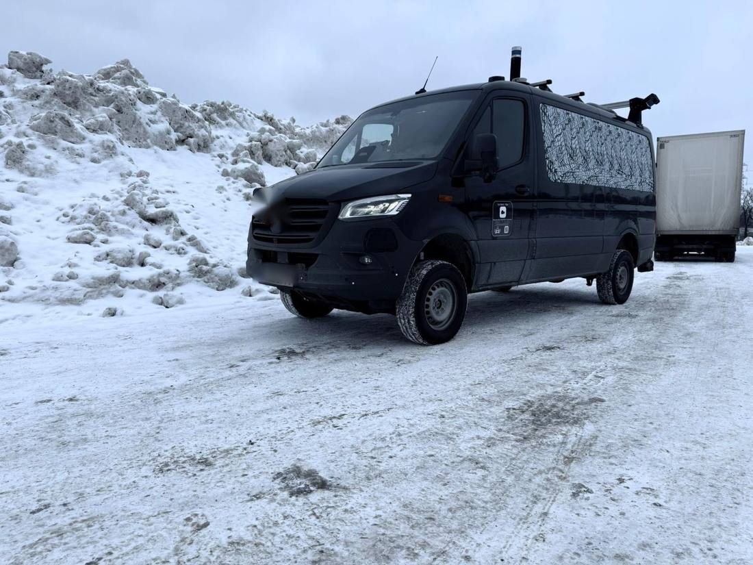 Van with roof-mounted sensor rig on an icy yard